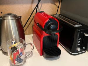 a red coffee maker sitting on a counter next to a toaster at Home à la mer in La Ciotat