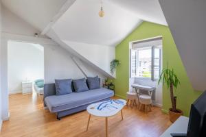 a living room with a couch and a table at Nid douillet au bord de l'erdre in Nantes