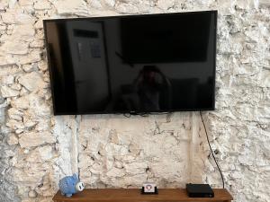 a flat screen tv hanging on a stone wall at Home à la mer in La Ciotat