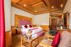 a hotel room with a bed and a couch at Sarthak Regency by M K Hospitality,Rangri, Manali,HP,Just 1 kms from Volvo parking in Manāli