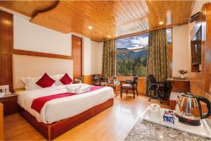 a bedroom with a bed and a large window at Sarthak Regency by M K Hospitality,Rangri, Manali,HP,Just 1 kms from Volvo parking in Manāli