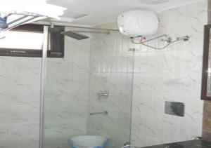 een badkamer met een douche en een glazen deur bij HOTELZO in New Delhi