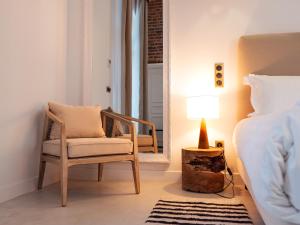 ein Schlafzimmer mit einem Stuhl, einem Spiegel und einem Bett in der Unterkunft Hôtel Château Héloïse 