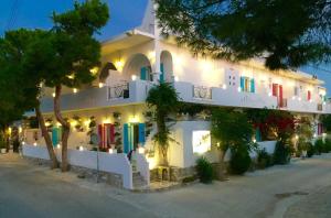 a white building with colorful doors and windows at night at Aphrodite Boutique Hotel in Aliki