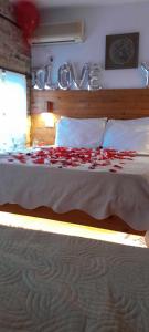 Un dormitorio con una cama con flores rojas. en Guest House Salaria en Gjirokastër