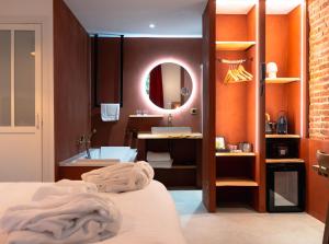 ein Bad mit einem Bett, einem Waschbecken und einem Spiegel in der Unterkunft Hôtel Château Héloïse 