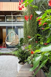 a garden with red flowers and a swing at The Modern Botanist Newtown in Sydney
