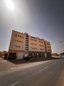 ein großes Gebäude an der Straßenseite in der Unterkunft Hotel Eloued فندق الوادي in Tiksebt