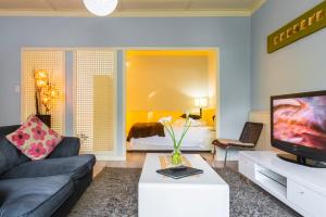un soggiorno con divano, TV e letto di Villa Margherita a Swakopmund