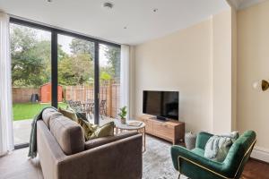 a living room with two couches and a tv at Richmond - Spacious 2 Bedroom Flat - With Garden in Richmond upon Thames