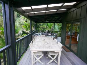 a wooden table on the deck of a house at Matakana Retreat - Luxury Off Grid Lodge in Nature in Matakana