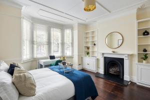 Un dormitorio con una cama grande y una chimenea. en Richmond - Spacious 2 Bedroom Flat - With Garden, en Richmond upon Thames