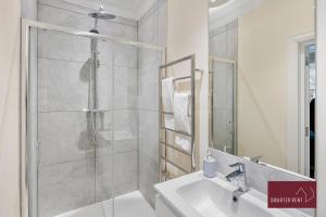 Un baño blanco con ducha y lavabo. en Richmond - Spacious 2 Bedroom Flat - With Garden, en Richmond upon Thames 14 fotos más