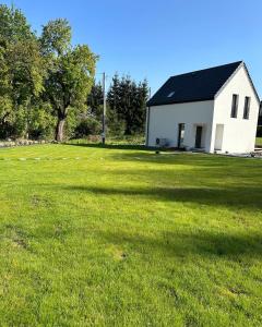 a white house with a large grass field at MINIMAL. Dom całoroczny w górach in Duszniki Zdrój