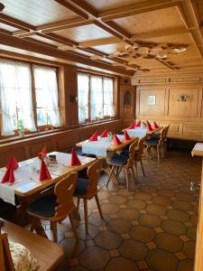 una sala da pranzo con tavoli e sedie con tovaglioli rossi di Zur Linde a Mühlheim an der Donau