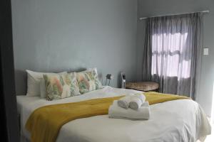 1 dormitorio con 1 cama con toallas en Berry Lane Guesthouse, en Kroonstad