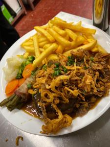 a white plate of food with french fries and meat at Zur Linde in Mühlheim an der Donau
