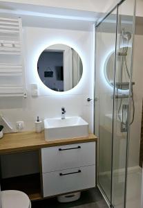 a bathroom with a sink and a shower at Apartament 2B Blue Marine Poddąbie in Poddąbie