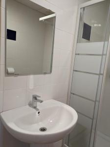 biała łazienka z umywalką i prysznicem w obiekcie Albergue Valmadrid 