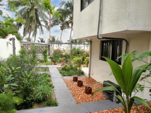 un jardín frente a un edificio con plantas en Maison de 4 chambres a Grand Popo a 10 m de la plage avec vue sur la mer piscine partagee et jardin clos en Grand-Popo