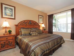 een slaapkamer met een groot bed en een raam bij Tosteth Villa 7766 in Orlando