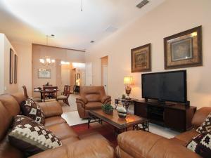 een woonkamer met lederen meubels en een flatscreen-tv bij Tosteth Villa 7766 in Orlando