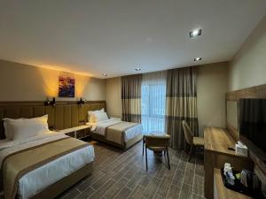 ein Hotelzimmer mit 2 Betten und einem TV in der Unterkunft Beyt Managed By Dedeman in Şırnak