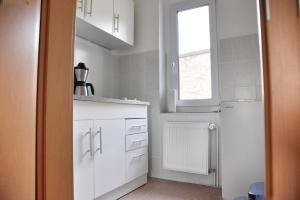 a kitchen with white cabinets and a window at Haus JuliaN Wohnung 1 in Ueckermünde