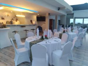 um salão de banquetes com mesas brancas e cadeiras brancas em Villa de Sarah em Lomé