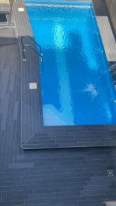 a large blue swimming pool with stairs in it at Villa de Sarah in Lomé