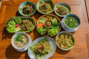 a group of bowls of food on a wooden table at U villa in Ban Huai Khai