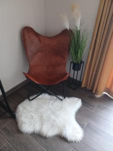 a brown chair with a white rug on the floor at Megalith Resort in Srednogorovo