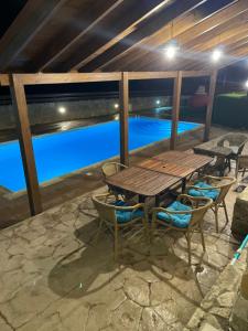 a wooden table and chairs next to a pool at Softades Cottage in Omodos