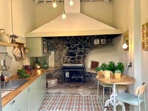 una cucina con tavolo e forno in pietra di La casa de los Barbazanes a Brion