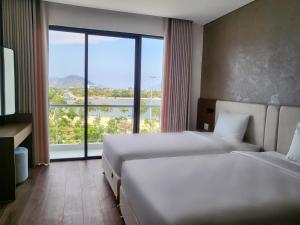 um quarto de hotel com duas camas e uma grande janela em Glamour Boutique em Kinh Dinh