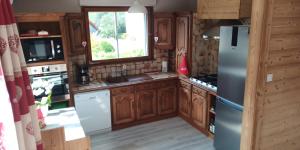Una cocina con gabinetes de madera y refrigerador. en La Fugue en Bresse, en La Bresse