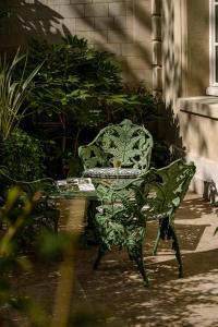 uma cadeira verde sentada ao lado de uma mesa em Saint James Paris em Paris