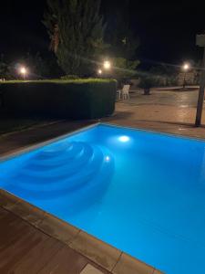 una piscina azul por la noche en Softades Cottage, en Omodos