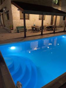 a swimming pool with blue lights in a building at Softades Cottage in Omodos