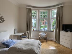 a bedroom with a bed and a desk and windows at Villa mit 4 Schlafzimmer in Bremen