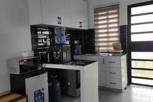a kitchen with white cabinets and a counter top at Epitome Apartment, Swara Ranch-Nanyuki in Nanyuki