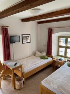 a hotel room with two beds and a tv at Gästehäuser St. Marienthal in Marienthal