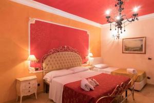 a bedroom with a bed and a red wall at Villa Margherita in Pozzallo