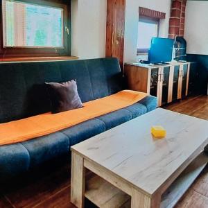 uma sala de estar com um sofá e uma mesa de centro em Vikendica Raj u prirodi em Prijedor