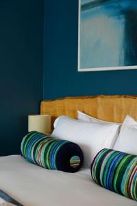 Una cama blanca con dos almohadas encima. en Arosfa Harbourside Guesthouse en Aberaeron