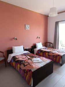 a hotel room with two beds and a window at GOLDEN BEACH in Souvala