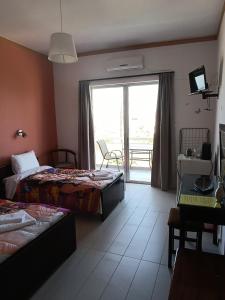 a hotel room with two beds and a balcony at GOLDEN BEACH in Souvala