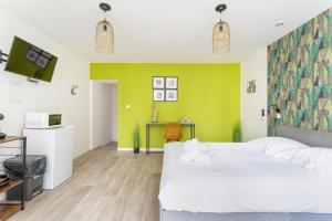 a bedroom with a white bed and a green wall at S&K Suite Grande rue Roubaix - Chambre spacieuse et SDB privée - Netflix et Cuisine in Roubaix