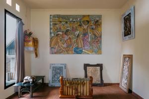 una stanza con un dipinto appeso al muro di Jati Home Stay ad Ubud