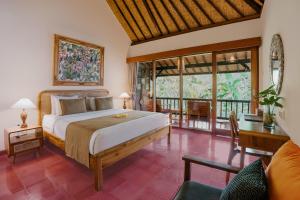 een slaapkamer met een groot bed en een balkon bij Jati Home Stay in Ubud